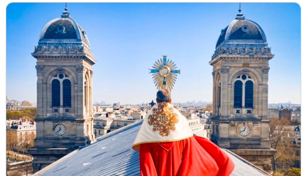 Priest carries Blessed Sacrament on rooftop of his Paris church…